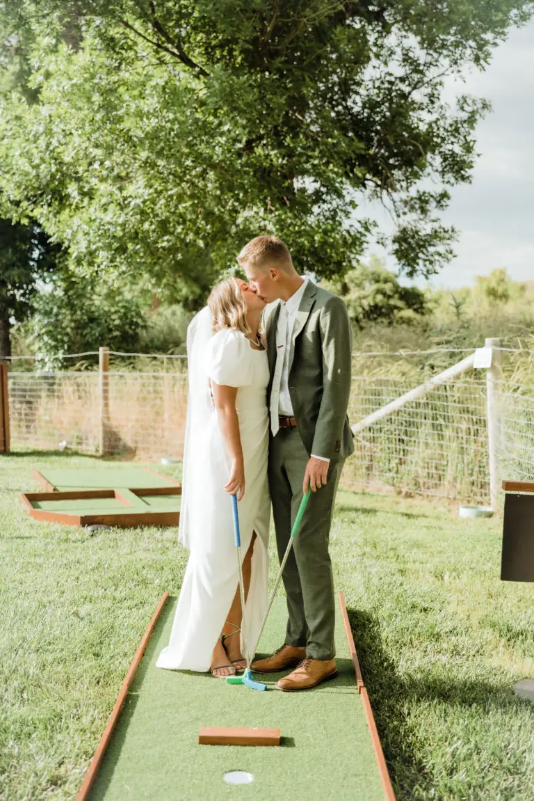 Couple kissing enjoying rented mini golf for the best wedding reception entertainment in Southern California